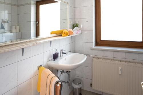 a white bathroom with a sink and a mirror at Ferienhaus Seeblick in Drobollach am Faakersee