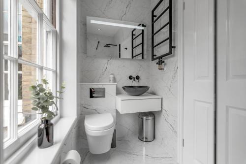 uma casa de banho branca com um lavatório e um WC em Central 6 Guest City Centre Church House em Norwich