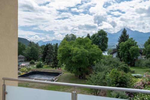 a balcony with a view of a park and mountains at Ferienhaus Seeblick in Drobollach am Faakersee