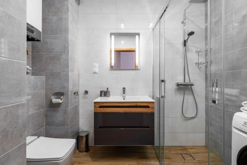 a bathroom with a shower and a toilet and a sink at Czarna Perła- Apartament przy Solisku in Szczyrk