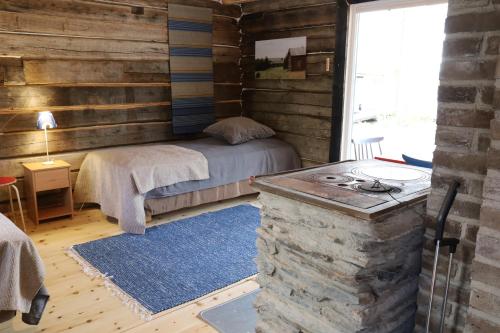 a bedroom with a bed in a log cabin at Kainuun Luontoretket in Hossa