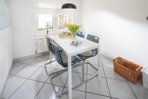 una mesa y sillas blancas en una habitación con ventana en Lüttje Schmiede en Norderney