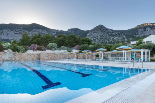 a swimming pool with mountains in the background at Hotel Brancamaria in Cala Gonone