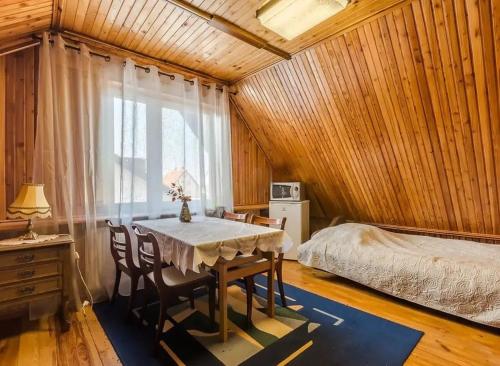 a dining room with a table and a bed at Pokoje Wilkasy in Wilkasy