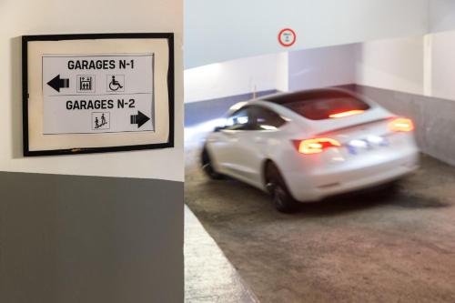 a car driving in a parking garage with a sign at Best Western Hotel Mediterranee Menton in Menton