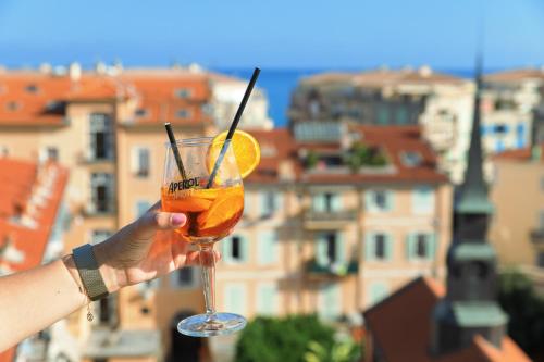 a person holding a glass with an orange at Best Western Hotel Mediterranee Menton in Menton