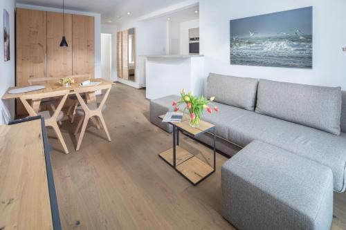 een woonkamer met een bank en een tafel bij Friesenhuus Friesenhuus Norderney, Whg 02 in Norderney