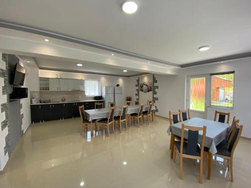 a dining room with tables and chairs and a kitchen at Casa Alberto in Sovata