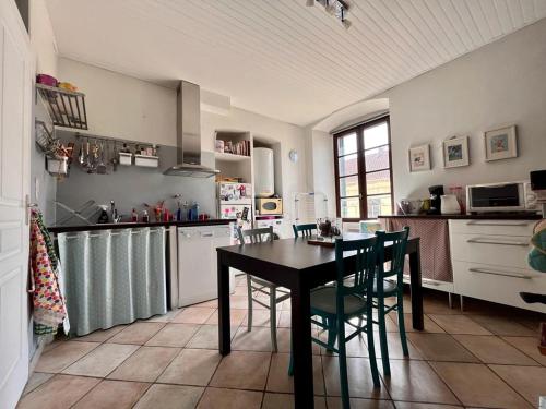 a kitchen with a table and chairs in a room at Joli appartement F2 centre ville de Corte in Corte
