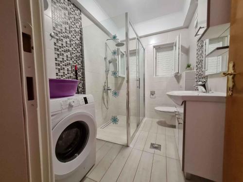 ein Badezimmer mit einer Waschmaschine und einem Waschbecken in der Unterkunft Apartments in Mundanije/Insel Rab 30445 in Mundanije