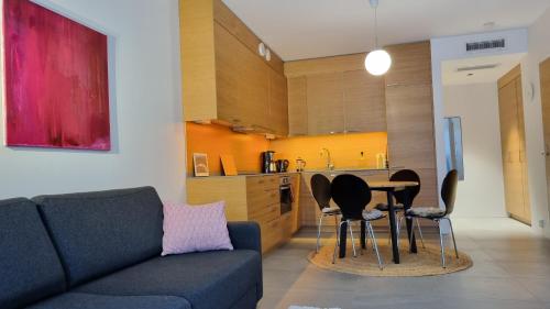 uma sala de estar com um sofá, uma mesa e cadeiras em Uusi, avara, saunallinen keskustakaksio em Tampere