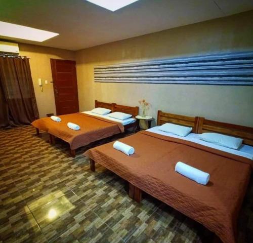 - deux lits dans une chambre d'hôtel avec deux couvre-lits dans l'établissement Casa De Cortijo Family Room, à Pagbilao