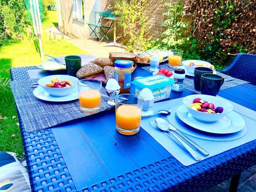 a blue picnic table with plates of food and orange juice at Back-Stage in Nijmegen