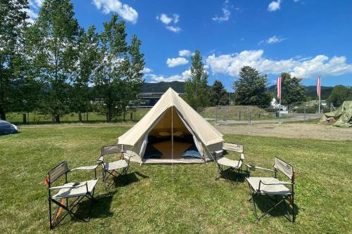 een tent met stoelen in een grasveld bij GrandPrixCamp, closest to the Red Bull Ring, up to 4 guests in a tent in Spielberg