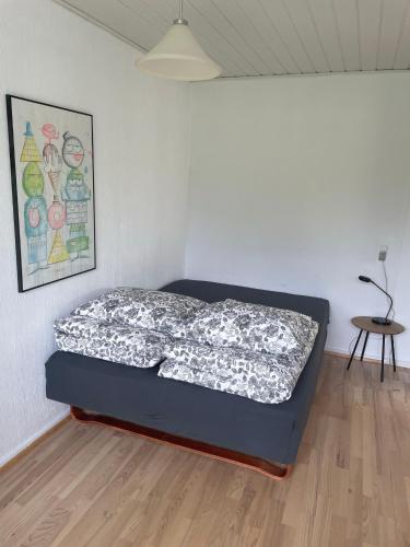 a bedroom with a bed in a room with a table at Feriehus-Gammel Byvej, Vrensted in Løkken