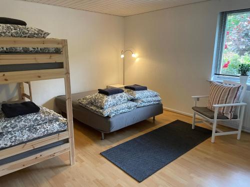 a bedroom with two bunk beds and a chair at Feriehus-Gammel Byvej, Vrensted in Løkken