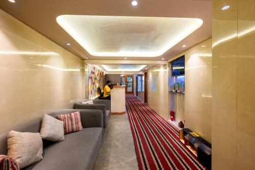 a living room with a couch and a red carpet at Hotel Balwas in Mumbai