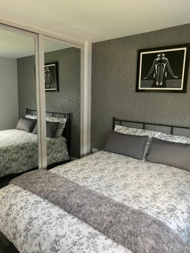 a bedroom with two beds and a large mirror at Shore Times Holiday Chalet Parkdean K75 in Camber