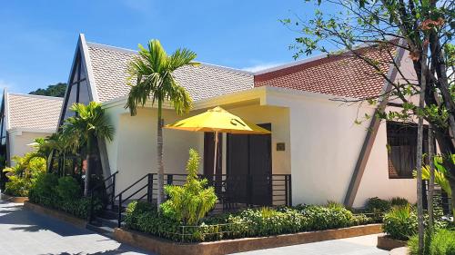 a house with a yellow umbrella in front of it at Vakara Hotel Kep in Kep