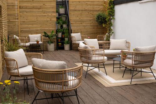a patio with wicker chairs and a couch and tables at Parador 44 in Cardiff
