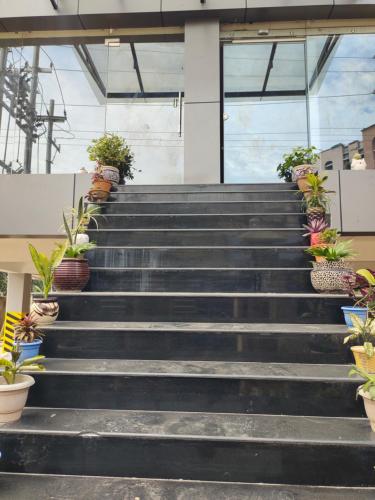 JD Grand Inn في غاواهاتي: مجموعة من الدرج مع نباتات الفخار عليها