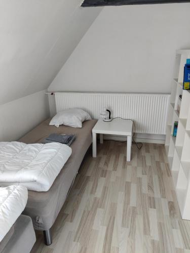 a bedroom with two beds and a table at 210 m2 hus med plads til 8 gæster in Nordborg