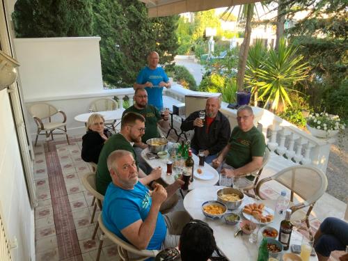 Un groupe de personnes assises autour d'une table et mangeant de la nourriture dans l'établissement Le Thimothée : Hôtel & Studios, à Saint-Raphaël
