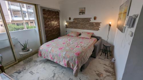 - une chambre avec un lit et une couette rose dans l'établissement Les Tambourins Studio 19 - 3 étoiles, à Cannes