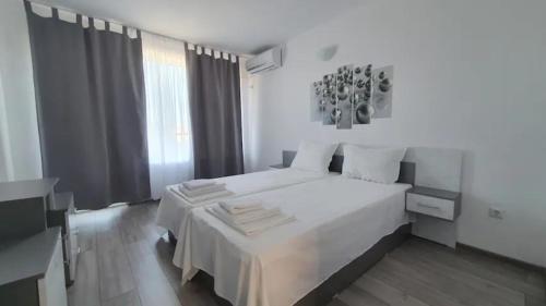 Къща за гости - Пролет في لوزينيتس: غرفة نوم بيضاء مع سرير أبيض ونافذة