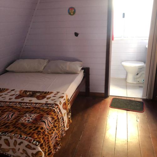 a bedroom with a bed and a toilet in a room at Chalé Dona Jandira in Sao Paulo