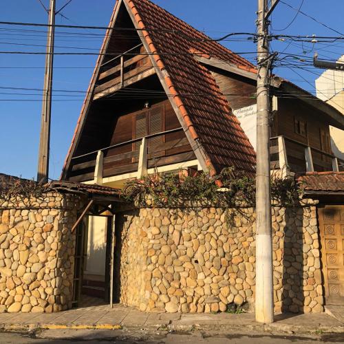 a building with a stone wall and a house at Chalé Dona Jandira in Sao Paulo