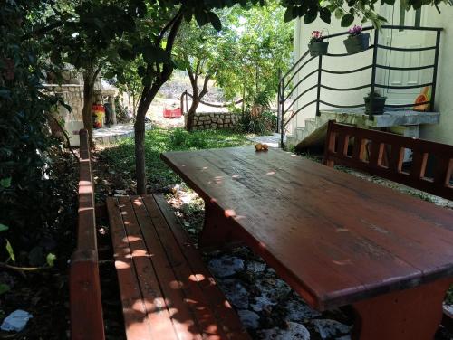 a wooden bench sitting in the shade of a tree at Holiday Home Free your mind in Dobra Voda
