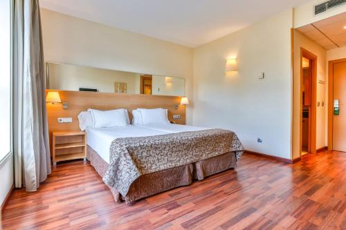 - une chambre avec un grand lit et du parquet dans l'établissement Hotel Desitges, à Sant Pere de Ribes