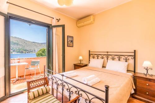 een slaapkamer met een bed en een balkon bij Villa Thalassia by Villa Plus in Kassiopi