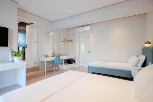 a white bedroom with a bed and a desk at Artis Blue Relax in Himare