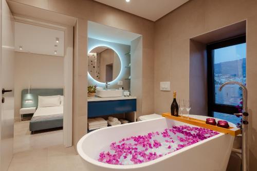 baño con bañera llena de flores rosas en Artis Blue Relax en Himare