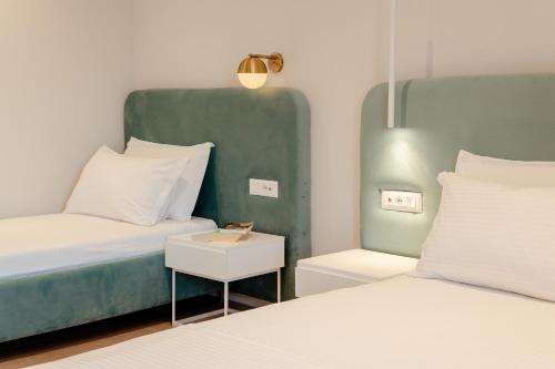 a bedroom with two beds and a couch and a table at Artis Blue Relax in Himare