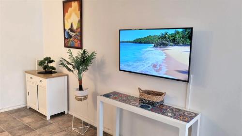 uma sala de estar com uma televisão na parede em Familiar y renovado departamento a pasos de playa em Viña del Mar