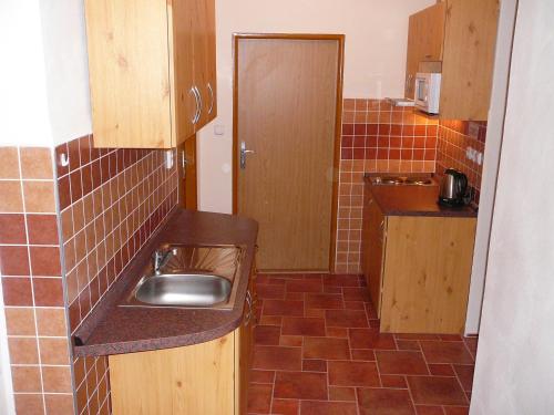 a kitchen with a sink and a tiled floor at Pension BRILLIA in Police nad Metují