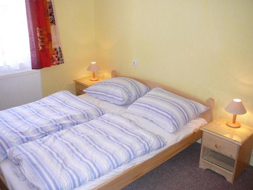 a bed in a bedroom with two lamps on tables at Pension BRILLIA in Police nad Metují
