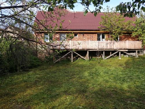 ein Backsteinhaus mit einer Holzterrasse im Hof in der Unterkunft Borlova /Muntele Mic in Borlova