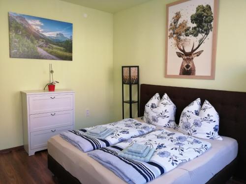 a bedroom with a bed with blue and white pillows at Ferienhaus Heideck in Heideck