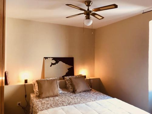 une chambre avec un lit avec un ventilateur de plafond dans l'établissement LA MINORQUIN appartement avec terrasse, à Port-Vendres