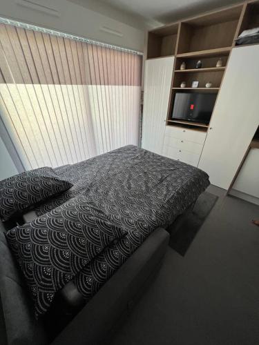 um quarto com uma cama e uma televisão em Appartement tout équipé centre ville Menton em Menton
