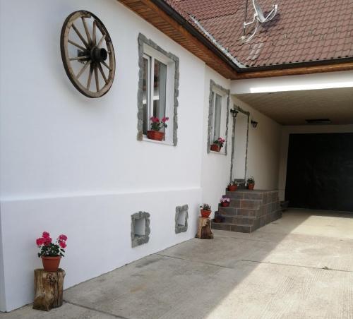 a white wall with a wheel on the side of a house at Borlova /Muntele Mic in Borlova