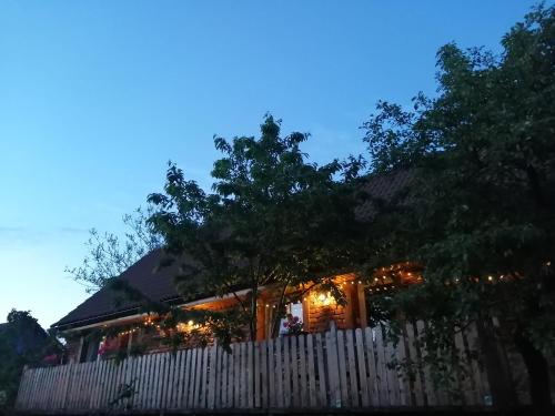 a house with a white fence and lights at Borlova /Muntele Mic in Borlova