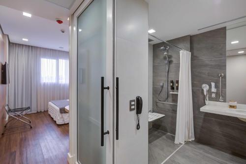 a bathroom with a shower and a sink at Rio Hotel by Bourbon Campinas in Campinas