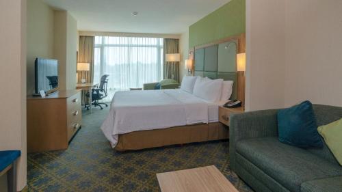 a hotel room with a bed and a couch at Holiday Inn Express & Suites Cuernavaca by IHG in Cuernavaca