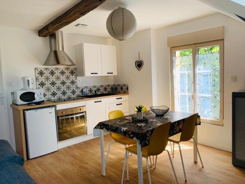 una cucina con tavolo e sedie gialle in una stanza di Centre ville (2): superbe appartement climatisé a La Flèche