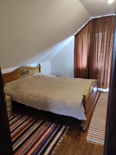 a bedroom with a bed and a rug at Casa Irilen in Mănăstirea Humorului